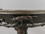 bronze sculpture of a woman holding a bowl with a cat on it
