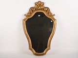une image d'un miroir encadré d'or sur un mur blanc
