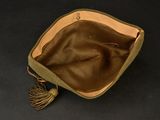 a brown bag with a tassel on a black surface