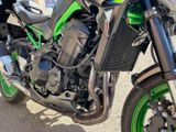 a green and black motorcycle parked on the side of the road