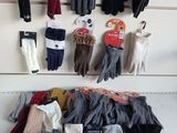 many pairs of gloves hanging on the wall next to each other