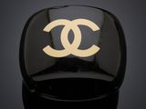 une bague noire et dorée ornée d'un logo blanc
