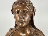 bronze statue of a woman with a bird on her head
