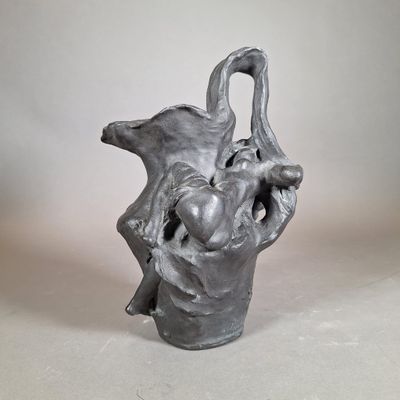 une sculpture représentant un vase dans lequel se trouvent un oiseau et un bébé