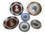 many different plates with pictures on them on a white surface
