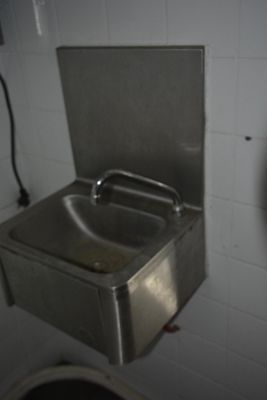 un évier en acier inoxydable dans le coin d'une salle de bains