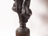 bronze bust of a man with a hat on top of a pedestal