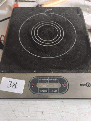 une plaque de cuisson noire et argentée posée sur un plan de travail blanc