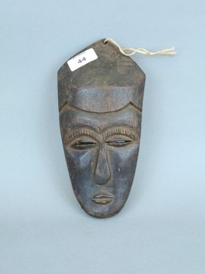 un gros plan d'un masque en bois muni d'une étiquette