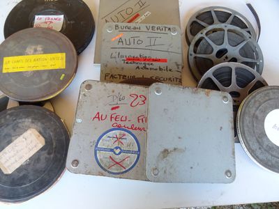 de nombreuses bobines de films anciens et d'autres objets posés sur une table