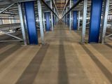 a long line of blue poles in the middle of a large warehouse