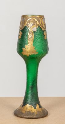un verre vert orné de motifs dorés