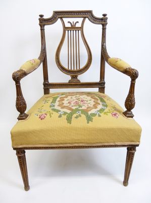 une vieille chaise avec une assise rembourrée jaune et un coussin à motifs floraux