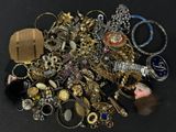a pile of assorted jewelry on a black surface