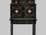 une armoire peinte en noir et or, surmontée de tiroirs
