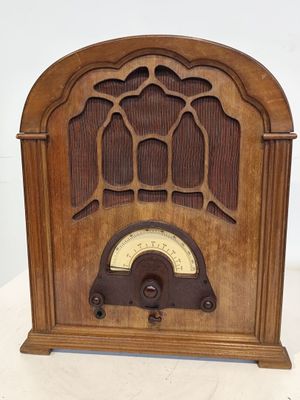une radio à l'ancienne posée sur une table blanche