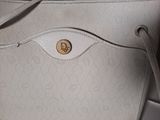 the inside of a white purse with a gold logo on it