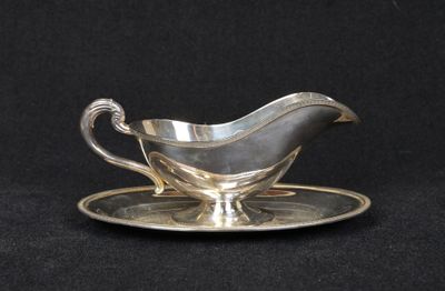 an antique silver plate with a saucer and saucer on a black background