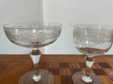 two wine glasses sitting on a table next to each other