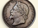 une vieille pièce de monnaie avec un visage d'homme sur une surface blanche
