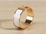 a close up of a gold and white ring on a wooden surface