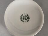 a close up of a white cup with a green logo on it