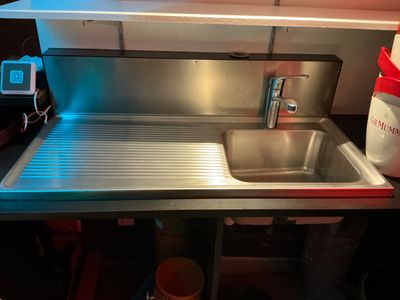 a sink in a small kitchen with a red light
