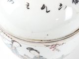 a white bowl with asian writing on it on a white surface