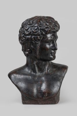 un buste en bronze représentant un jeune homme aux cheveux bouclés
