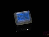 un gros plan d'une pierre bleue carrée posée sur une surface noire