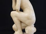 marble statue of a man sitting on a pedestal with his head in his hands