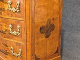 a small wooden chest of drawers on a grey background