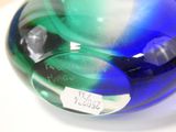 a blue and green glass object on a white surface