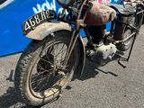 une vieille moto garée devant un bus