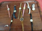 de nombreux modèles de montres posés sur un plateau posé sur une table
