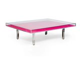 une table basse rose avec un plateau en verre et des pieds en métal