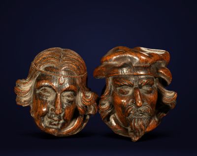 paire de têtes en bois sculptées représentant deux hommes portant un chapeau et une barbe