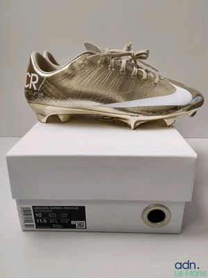 a close up of a pair of gold shoes on a white box