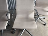three office chairs sitting next to each other in front of a metal wall