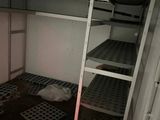 a small room with a ladder and a microwave on the wall
