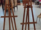 two easels in a room with paintings on the walls