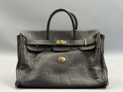 a grey leather handbag with gold hardware on the handle