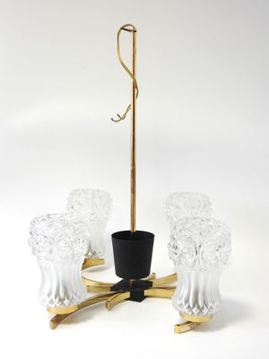 brass and glass chandelier with four clear glass vases on a stand