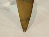 a gold vase that is sitting on a white surface