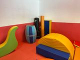 a play area with a slide and a tent in the corner
