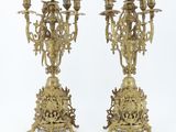 pair of antique brass candelabs on pedestals on a white background