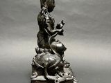 a statue of a person sitting on top of a turtle