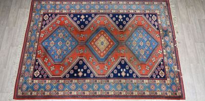 an orange, blue, and red rug on a wooden floor