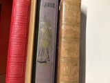 several books are stacked on a shelf in a room