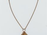 a gold necklace with an ornate design on a chain